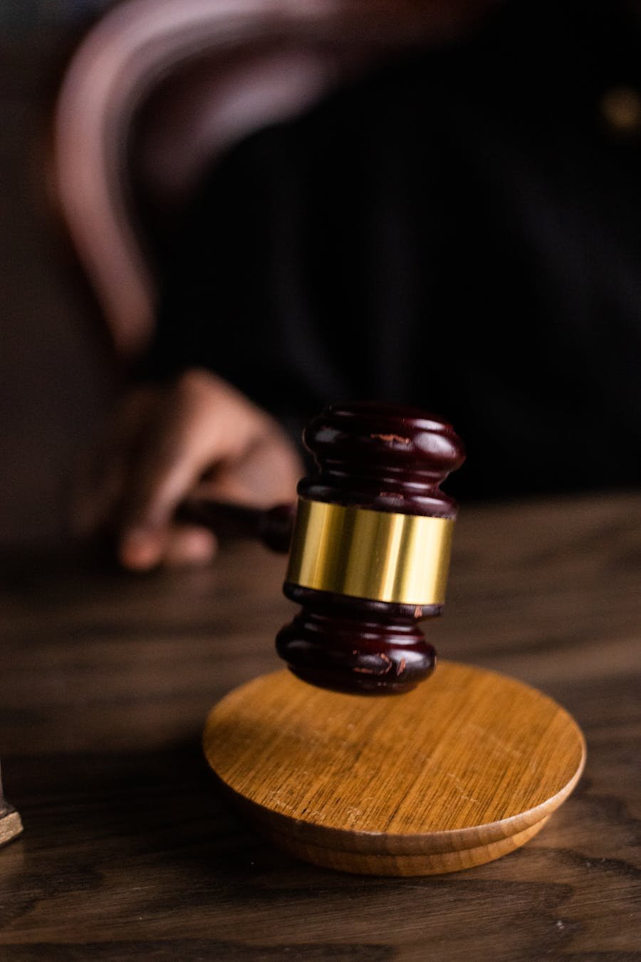 Close-up of a judge's gavel on a wooden block.
