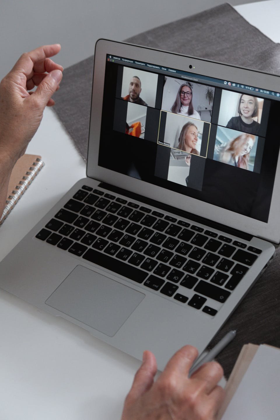 Hands at a laptop during a video interpretation session.